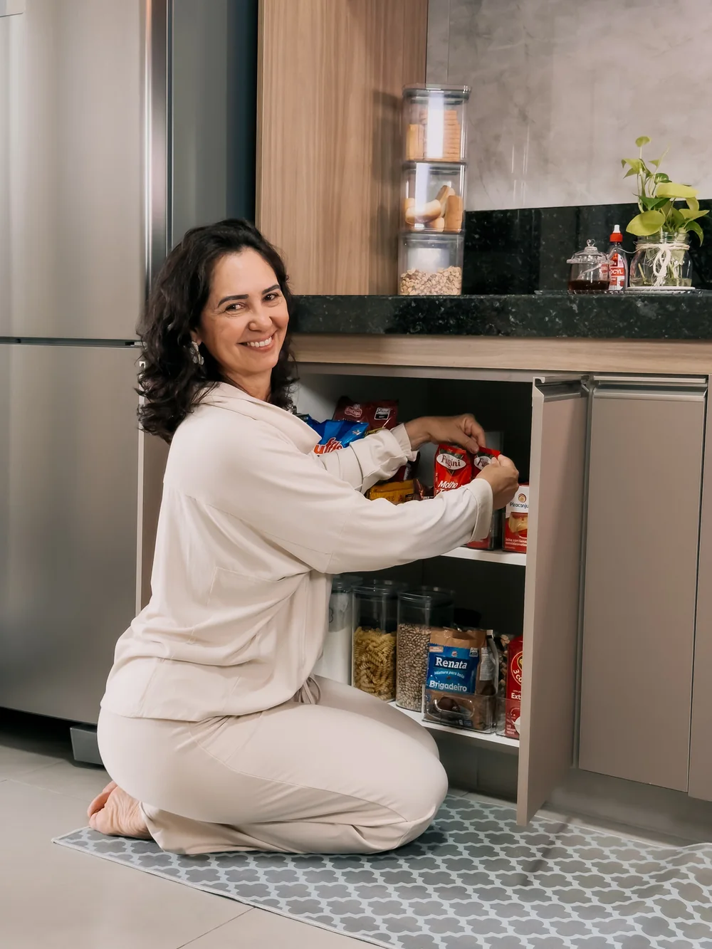 Micheli organizando potes em um armário